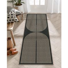 a black and white runner rug with circles on the floor in front of a window