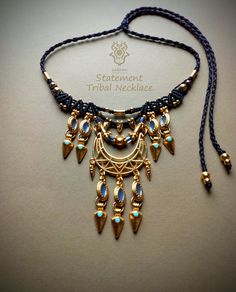 Unique macrame tribal necklace. Polyester waxed thread: Linhasita total black.  Macrame design:  Height: 7,80 cm or 3,07 inches. Width: 8,00 cm or 3,14 inches. Adjustable with a sliding knot. Beads: blue. Brass enamel charms: light gold with blue. Brass triangle charms: gold with turquoise.  Brass beads: light gold. Brass tribal connector: light gold. All brass elements: nickel & lead free, colored gold, not real gold. *Every piece is designed with attention using high quality materials. Polyest Brown Macrame Necklace For Festival, Bohemian Ceremonial Metal Necklace, Bohemian Festival Hand-strung Necklaces, Adjustable Brass Necklace With Macrame, Gold Brass Macrame Necklace, Necklace Macrame, Festival Necklace, Total Black, Festival Jewelry