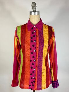 "Check out this colorful, pattern-FUL, one-of-a-kind button down shirt! This fabulous shirt, originally designed by Alpana Bawa, has been lovingly re-done with a 'creative repair': as an ode to patterns, each panel has a different theme print that has been hand-drawn. This is a classic, light-weight woven cotton button-down shirt with full length sleeves and flat, real shell, carved buttons. Marked size Large. The patterns/prints are as follows: Front right; polka dot, brick, wood grain, cross-hatchery, beaded curtain & paisley Right cuff features gingham Back right; paisley, static/scribbles, sunbursts, plaid, checkered, vine & animal print Back left; citrus fruits, pebbles, Greek key, time + space, ditsy & zipper Left cuff features houndstooth Front left; curly-q's, cascading hair, honey Multicolor Collared Shirt With Vibrant Print, Multicolor Long Sleeve Shirt With Graphic Print, Multicolor Long Sleeve Shirt With Button Closure, Patterned Vibrant Print Collared Shirt, Colorful Patterned Shirt For Fall, Multicolor Printed Button-up Shirt, Multicolor Vibrant Print Button-up Shirt, Multicolor Long Sleeve Shirt With Vibrant Print, Multicolor Long Sleeve Shirt With Buttons