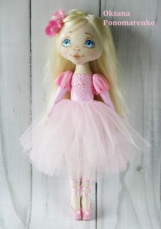 a doll with blonde hair and blue eyes is wearing a pink tutu skirt, tights and shoes