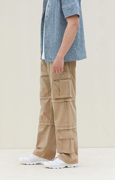 Experience ultimate versatility and durability with PacSun's Tan Baggy Cargo Zip-Off Pants. Crafted from cotton with a drawstring waistline, these pants boast ample storage with side and cargo pockets, while offering the convenience of zip-off legs for instant shorts transformation. Finished with additional cargo pockets near the hem, they ensure both style and functionality for your adventurous outings. Full-length Cotton Parachute Pants With Pockets, Full Length Cotton Parachute Pants With Pockets, Cotton Full-length Parachute Pants With Pockets, Utility Cotton Parachute Pants Full Length, Khaki Cotton Parachute Pants With Multiple Pockets, Baggy Cotton Cargo Jeans For Outdoor, Beige Cargo Pants With Side Pockets For Outdoor Activities, Full Length Cotton Cargo Jeans With Elastic Waistband, Cotton Parachute Pants With Pockets For Outdoor Activities