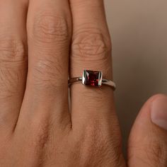 This is a gorgeous handmade creation. Its beauty is its simplicity & Elegance. The 6*6 mm Princess cut garnet (about 1.51 ct) is crafted in solid sterling silver or 14k white/rose/yellow gold All item is sent in a beautiful gift box If you have any idea of design your ring,pls contact me directly. You can realize more lovely stuff clicking the link https://www.etsy.com/shop/knightjewelry?refshopsection_shophome_leftnav Please leave the correct address and you phone number for delivering succ Garnet Solitaire Ring As Gift, Fine Jewelry Garnet Ruby Ring With Bezel Setting, Garnet Solitaire Jewelry As Gift, Garnet Solitaire Jewelry Gift, Garnet Round Cut Rings For Gift, Garnet Round Cut Rings As Gift, Garnet Emerald Cut Promise Ring, Classic Garnet Rings With Bezel Setting, Princess Cut Ruby Rings Suitable For Gift