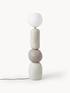 a lamp that is sitting on top of some rocks and has a white ball on it