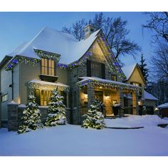 a house covered in christmas lights and snow