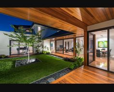 the inside of a modern house with wood floors and green grass on the lawn area