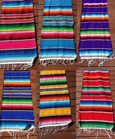 six colorful towels laid out on top of a wooden floor with fringes hanging from them