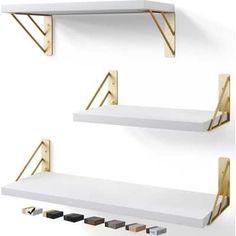 two white shelves with gold brackets and some black ones