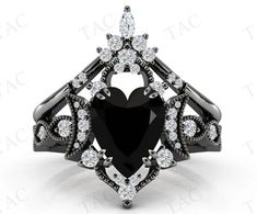 a heart shaped black diamond ring with white diamonds on the sides and an intricate design in the center