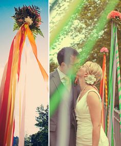 a couple standing next to each other in front of flags and rainbow colored streamers