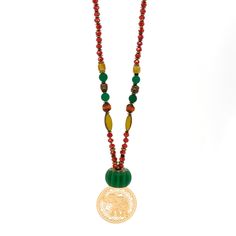 This Mystic Bohemian Elephant Necklace is a unique and colorful piece of jewelry that combines bohemian style with a touch of mysticism. The necklace features a combination of different beads including clear crystal beads, green jade beads, and colorful African beads. It also includes gold-colored hematite stone beads, gold-colored hematite Buddha beads, and gold-colored hematite stone heart beads. The necklace is highlighted by a handmade glass green color floral large bead, and it is finished Handmade Green Beaded Necklaces For Festivals, Bohemian Green Crystal Necklaces With Gemstone Beads, Bohemian Green Crystal Necklace With Colorful Beads, Bohemian Czech Glass Faceted Beads, Eclectic Green Round Bead Jewelry, Artisan Green Beaded Necklaces For Festivals, Green Beaded Chain Necklace For Festivals, Amulet Style Wooden Beaded Necklaces For Gifts, Bohemian Faceted Beads, Gems, And Cabochons For Gifts