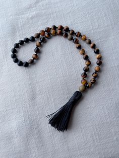 🍃every ninth bead is marked  with a 8mm green saldalwood bead (total of four) 🍃Japa mala of 45 beads  🍃Handmade tassel with the same cord that holds the beads 🍃sandalwood guru bead  🍃natural stones beads: black matte onyx  7.5 to 8mm beads light Tiger eye 8mm 🍃Microfiber bag included Spiritual Rosary With Round Beads For Meditation, Spiritual Rosary For Meditation With Round Beads, Meditation Rosary With 108 Beads, Spiritual Wooden Beads Rosary For Meditation, Adjustable Natural Stones Rosary For Meditation, Spiritual Rosary With Wooden Beads For Meditation, Spiritual Hand-strung Rosary For Meditation, Natural Stone Rosary With Round Beads For Meditation, Rosary With Natural Stones For Meditation