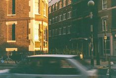 a blurry image of a car driving down the street in front of some buildings