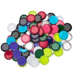 a pile of colorful bottle caps sitting next to each other on top of a white surface