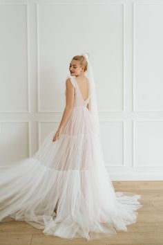 a woman in a wedding dress standing on the floor with her back to the camera