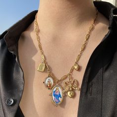 Bow and Book Necklace, 18K yellow gold (750/1000). Chain: 50.8cm length. • Large hand-painted enamel “The Immaculate Conception” medal. Set with 0.28 carats of white diamonds and 0.52 carats of yellow sapphires. Measurements 25mm width, 35mm length. • Medium hand-painted enamel “Our Lady of Carmel” medal. Set with 0.36 carats of pink sapphires and 0.16 carats of black diamonds. Measurements 25mm width, 35mm length. ��• Vintage French mechanical art nouveau book charm. Measurements 10mm width, 15mm Lucky Charm Necklace, Book Necklace, Mechanical Art, Vintage Pocket Watch, Immaculate Conception, Lock Necklace, Pocket Watch Chain, Zodiac Pendant, Charm Necklaces