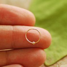 ♥ The perfect gift for you or your loved ones ♥ SINGLE hoop earring with a tiny 14k gold / silver sterling ball Please note - tiny bead is not glued to the hoop, it moves along the hoop. ★PLEASE choose★: - hoop with secure locking clasp - hoop with tiny claps -please see photo #3 or - infinity endless hoop - hoop without clasp - please see photo #4 Please choose material: ★100% 14K gold filled ★ ★100% Silver Sterling ★ *you can choose also mix option - silver hoop with gold filed ball or gold fi Tiny Minimalist Small Hoop Piercings, Minimalist Internally Threaded Huggie Nose Rings, Delicate Cartilage Earrings Gift, Minimalist Small Hoop Internally Threaded Septum Ring, Dainty Cartilage Earrings As A Gift, Delicate Small Hoop Cartilage Earrings As Gift, Minimalist Small Hoop Septum Ring With Internal Threading, Dainty Round Cartilage Earrings As Gift, Delicate Round Cartilage Earrings