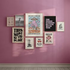 a pink wall with posters on it and a wooden floor in front of the wall