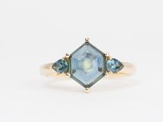 three stone ring in yellow gold with blue topazte and diamonds on the sides