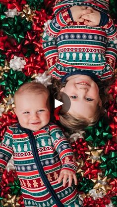 two babies laying on top of red and green christmas tinsel with presents around them