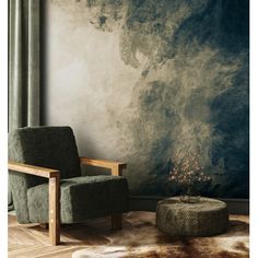 a chair and ottoman in front of a wall with an artistic painting on the wall