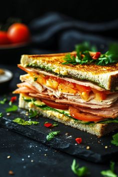 Stacked sandwich with turkey, cheese, tomatoes, and greens on a black slate surface. Sandwich Photography Ideas, Sandwiches Pictures, Festive Sandwiches, Sandwiches For A Party, Sandwich Meals, Fall Sandwiches, Sandwiches For Dinner, Homemade Sandwiches