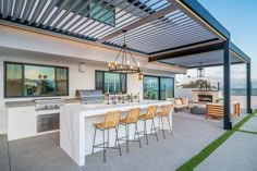 an outdoor kitchen and dining area on the roof of a house with ocean view in the background