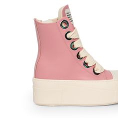 The sneakers are high-top platform-style shoes with a dominant color scheme of pink and cream. They feature a thick, cream-colored rubber sole with layered detailing that gives the shoe a bold and chunky silhouette. The upper part of the sneakers is primarily fuxia, constructed with leather material. The design includes metal eyelets for the laces, which are cream-colored and chunky, complementing the sole. Pink Light, Pink Leather, Leather Material, Color Scheme, Cream Color, High Top, High Tops, Rubber Sole, Color Schemes