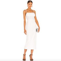 a woman is wearing a white dress with straps and heels on the heeled shoes