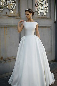 a woman in a white wedding dress standing outside