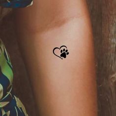 a woman's arm with a tattoo on it that has a dog paw in the shape of a heart