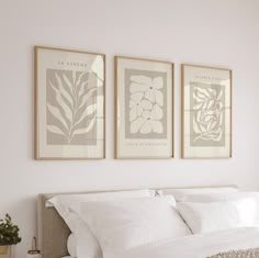 three framed pictures hang above a bed in a bedroom