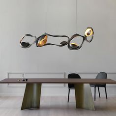 a dining room table with three lights hanging from it's sides and two chairs on the other side