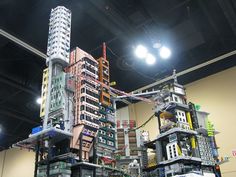 a very tall building surrounded by lots of different types of construction equipment and lights on the ceiling