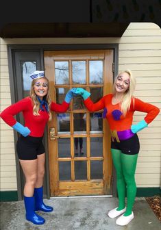 two women dressed in costumes standing next to each other on the front steps of a house