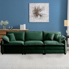 a living room with blue walls and a green couch in the middle of the room