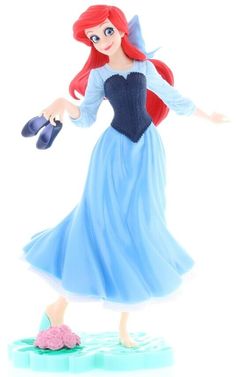 the little mermaid figurine is wearing a blue dress and holding a pair of shoes