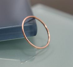 a gold ring sitting on top of a table next to a blue tablet pc computer