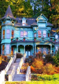 a large blue house with lots of windows on it's sides and stairs leading up to the front door