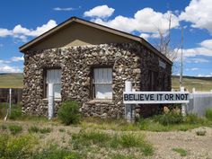 a stone building with a sign that says believe it or not in front of it