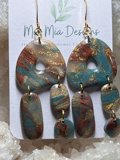 These adorable abstract earrings are handcrafted using translucent polymer colored with blue, rust with added gold leafing to create a one-of-a-kind pair of earrings.  Assembled using gold embellishments, these earrings are both lightweight and hypoallergenic. Turquoise Resin Earrings For Gift, Turquoise Dangle Earrings In Resin, Artsy Blue Teardrop Earrings, Bohemian Gold Resin Earrings, Handmade Turquoise Resin Earrings, Artsy Blue Dangle Earrings, Unique Teardrop Resin Earrings, Blue Artsy Resin Earrings, Artsy Blue Resin Earrings