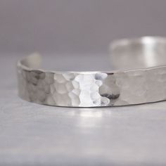 "Indulge in long-lasting wear and plenty of shimmer with this hammered sterling silver cuff from Pure Impressions. Hand-tailored in minute detail, it features a stunning silver cuff that has been textured with hammered detailing. It slips on with ease and is an ideal piece for daily wear. It looks stunning with business or casual wear and will give your look a touch of stylishness. It also makes a thoughtful gift idea for any occasion. This is an original Pure Impressions creation. ♥ Choose your Modern Hammered Cuff Bangle, Silver Hammered Cuff Bracelet, Adjustable Open Cuff Bracelet With Polished Finish, Classic Hammered Cuff Bracelet, Modern Hammered Cuff Bracelet As Gift, Adjustable Polished Cuff Bracelet For Weddings, Classic Cuff Bangle For Anniversary, Classic Cuff Bangle, Silver Open Cuff Bracelet For Gift