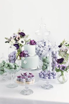 a table topped with lots of cakes and flowers