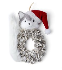 a christmas wreath with a stuffed animal in the middle and a santa's hat on top