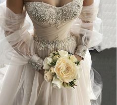 a woman in a wedding dress holding a bridal bouquet