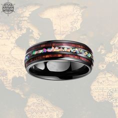 a wedding band with colorful stones inlayed to the inside of it on top of a world map