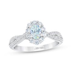 a white gold engagement ring with an oval center surrounded by round brilliant cut diamonds and pave set shoulders