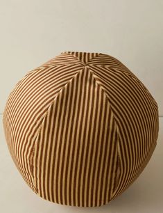 a brown and white striped bean bag sitting on top of a table