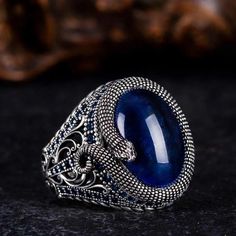 Step into the realm of mystique with our captivating Blue Tiger's Eye Ring adorned with intricate snake detailing. Crafted with care, this ring features a mesmerizing blue tiger's eye stone, exuding an aura of depth and allure. The snake motif, delicately engraved, adds an element of intrigue and symbolism to the design. Accented with shimmering zircon stones, this ring is a true statement piece that commands attention. Whether worn as a symbol of transformation or simply as a stunning accessory Snake Motif, Tigers Eye Ring, Blue Tiger Eye Stone, Grand Bazaar Istanbul, Thoughtful Gifts For Him, Jewelry Mens, Blue Tigers, Bold Jewelry, Blue Tigers Eye