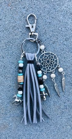 a tasseled keychain with beads and charms hanging from it's side