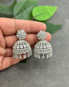 Elevate your style with our Exquisite High-Quality American Diamond Jhumka Earrings, a stunning blend of traditional craftsmanship and contemporary design. These earrings feature meticulously selected American diamonds, each set with precision to radiate brilliance and sophistication. The intricate Jhumka design is a timeless symbol of elegance, perfect for any occasion--be it a grand celebration or a simple evening out. The earrings are crafted from premium materials, ensuring they not only daz Luxury Cutdana Jhumkas For Eid, Luxury Jhumkas With Intricate Design, Luxury Silver Jhumkas For Diwali, Luxury Traditional American Diamond Jhumkas, Luxury Bollywood Hand Set Jhumkas, Luxury Jhumkas For Reception And Festive Occasions, Luxury Bridal Sets With Intricate Design For Celebration, Wedding Jhumkas With Intricate Cubic Zirconia Design, Wedding Cubic Zirconia Jhumkas With Intricate Design